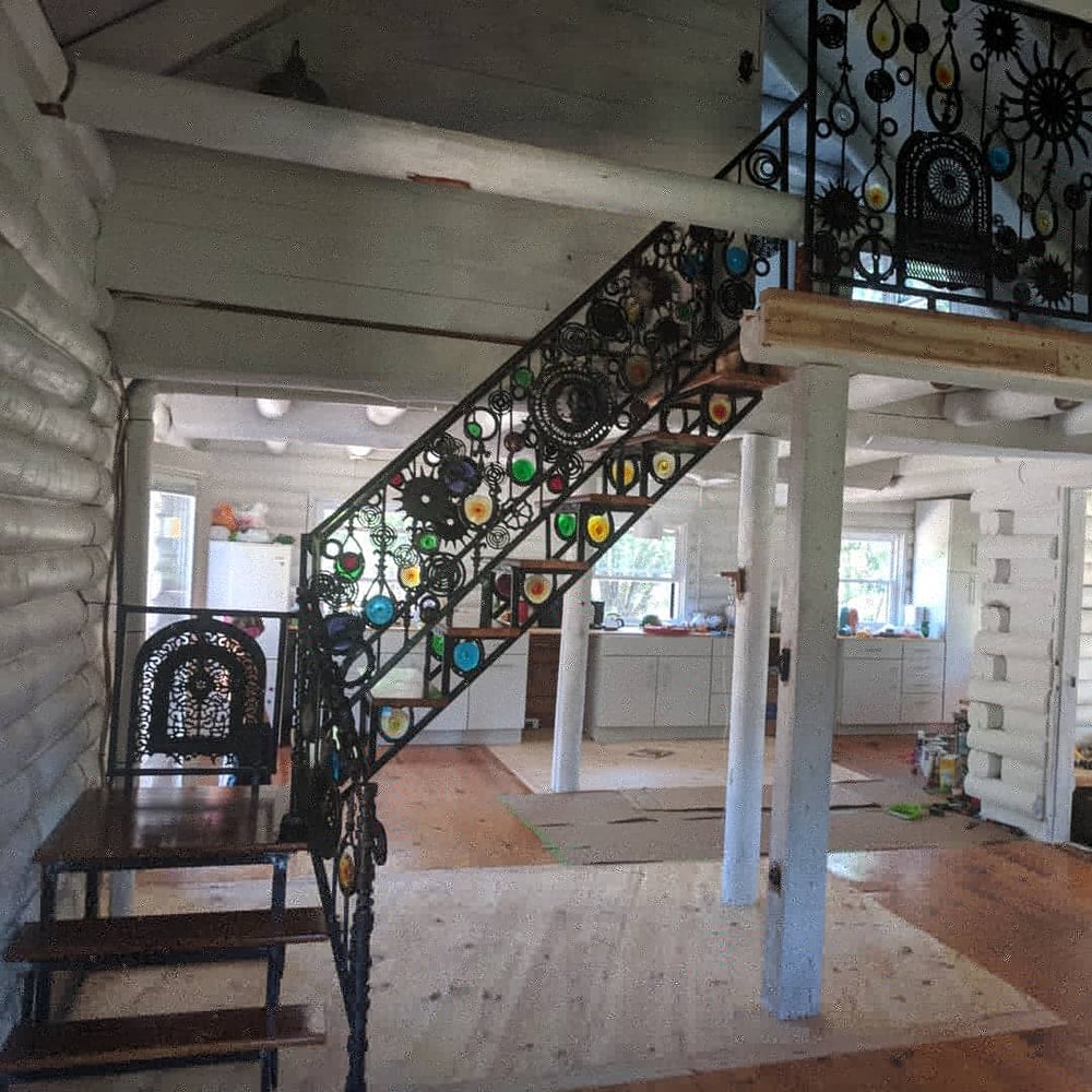 Custom metal staircase with glass inserts and bleacher wood steps by by Rusty Pelican Art
